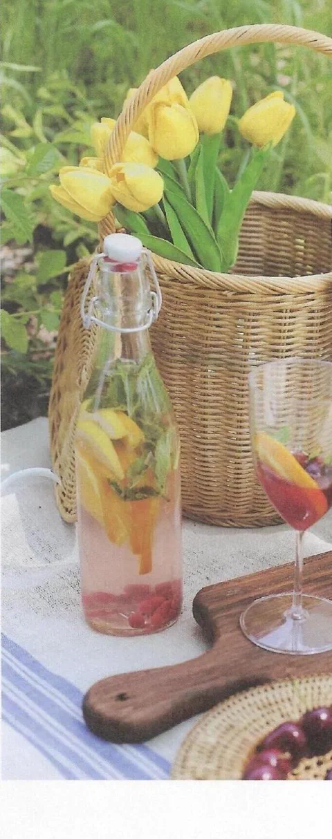 Bebida de picnic de primavera, en una botella con fruta en rodajas