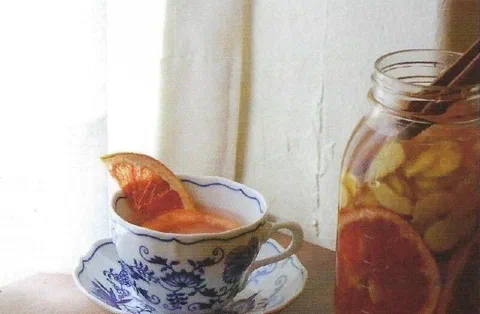 Té de toronja y jengibre, servido en una taza con una rodaja de toronja de decoración
