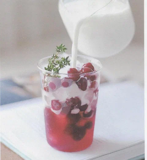 Cranberry con leche, con cranberries y hierbas de decoración