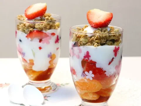 Granola con yogur, con cereza y flores comestibles encima
