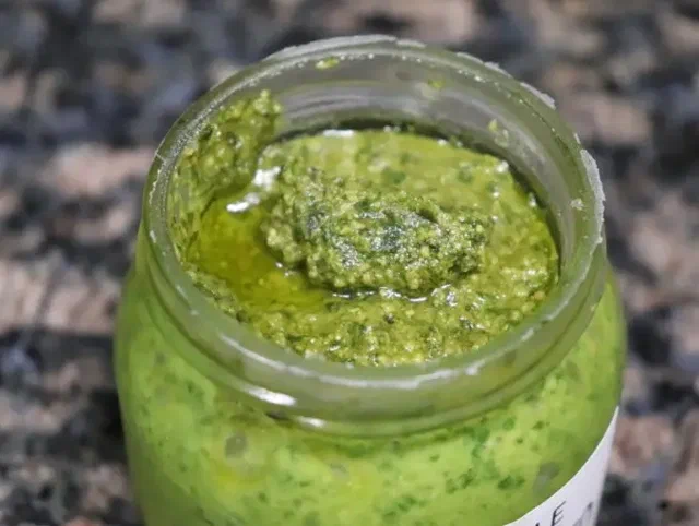 Pesto de albahaca en un frasco de vidrio, base del aderezo de pesto