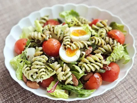 Fusilli al pesto con tomate seco, parmesano y hojas de albahaca