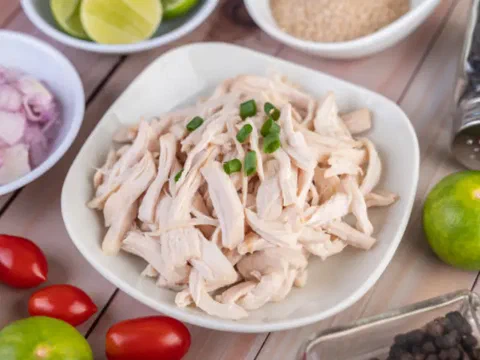 Salad chicken deshilachada, servida con tomate cherry, limón y cebolla morada