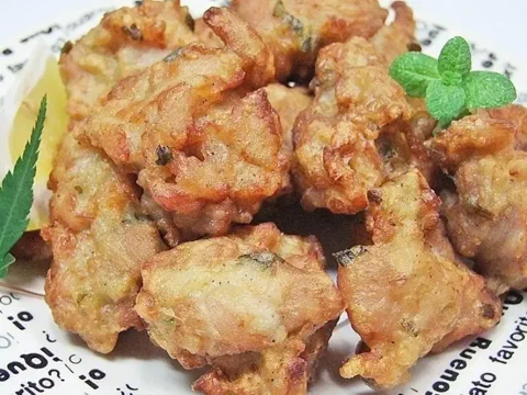Bocados de pechuga de pollo en tempura, dorados y esponjosos, sobre repollo