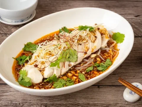 Pechuga de pollo yodare-dori en rebanadas sobre frejolito chino, bañada en salsa picante