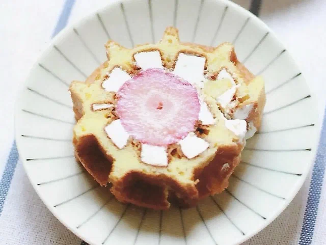 Rebanada de rollo de waffle mostrando el relleno de crema y fruta en espiral